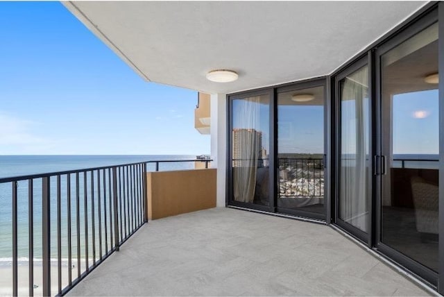 balcony featuring a water view and a view of the beach