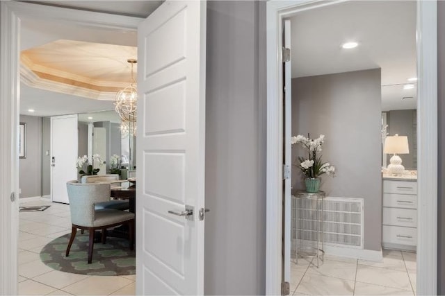 bathroom featuring ornamental molding, a chandelier, and a raised ceiling