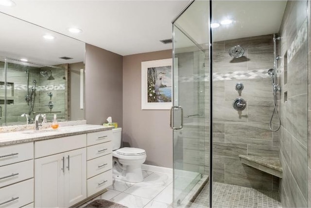 bathroom with vanity, toilet, and a shower with shower door