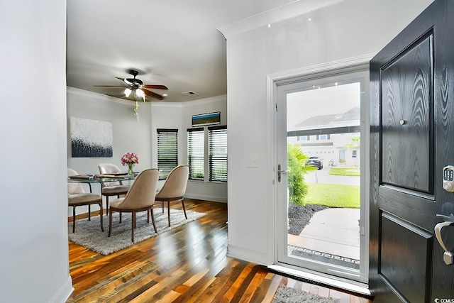 foyer entrance with dark hardwood / wood-style floors, ceiling fan, and ornamental molding