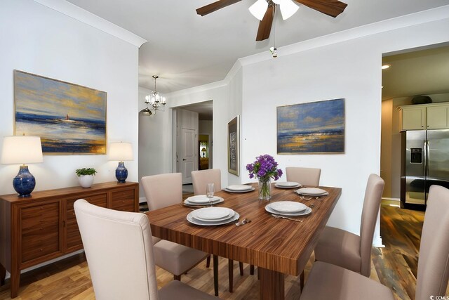 dining area with ceiling fan with notable chandelier, wood-type flooring, and crown molding