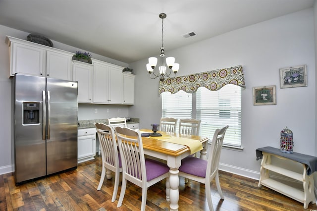 dining area with a notable chandelier and dark hardwood / wood-style flooring