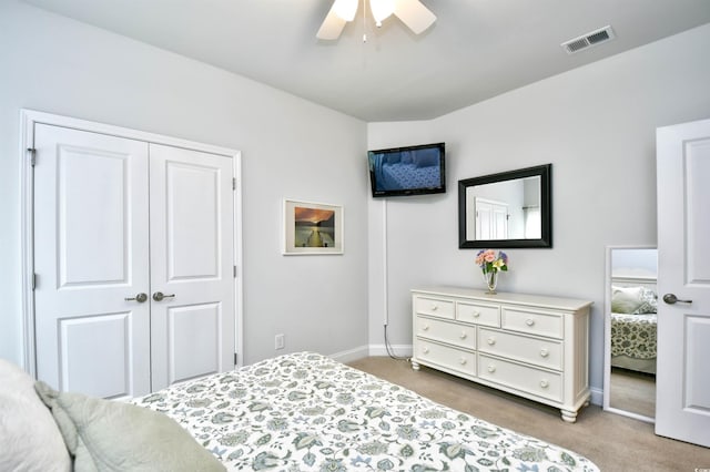 carpeted bedroom featuring ceiling fan and a closet