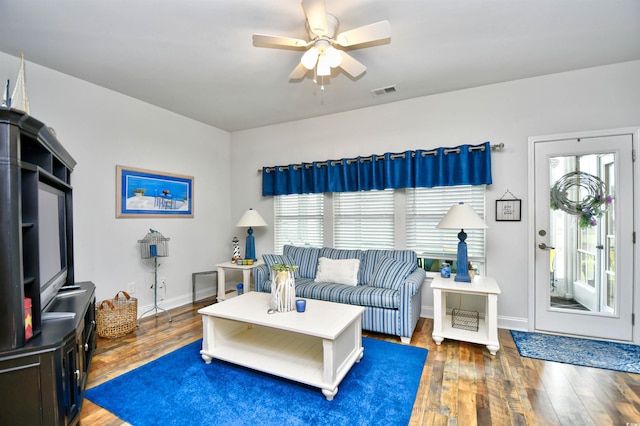 living room featuring ceiling fan and dark hardwood / wood-style floors