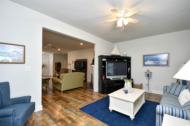 living room featuring ceiling fan and dark wood-type flooring