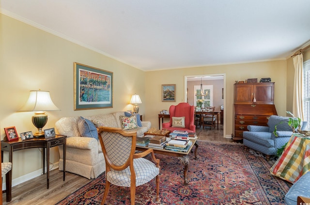 living room with crown molding, wood-type flooring, and a healthy amount of sunlight