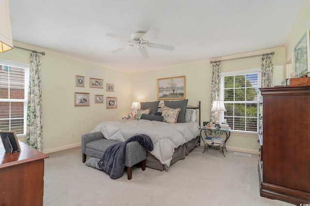 bedroom with ornamental molding, light colored carpet, and ceiling fan