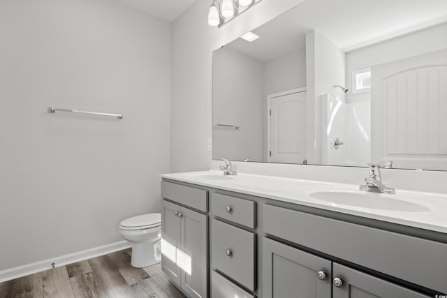 bathroom with wood-type flooring, a shower, vanity, and toilet