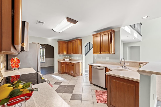 kitchen featuring appliances with stainless steel finishes, kitchen peninsula, sink, and light tile patterned floors