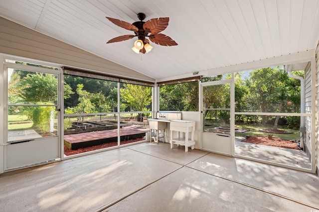 unfurnished sunroom with ceiling fan, wood ceiling, and vaulted ceiling