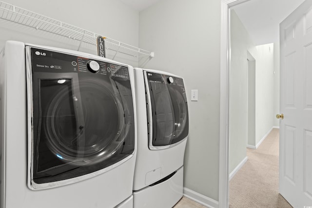 laundry area featuring washing machine and clothes dryer and light colored carpet