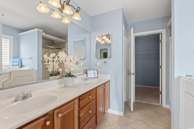 bathroom with tile patterned flooring, vanity, and a shower with door