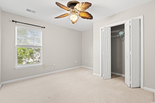 unfurnished bedroom with light carpet, a closet, and ceiling fan