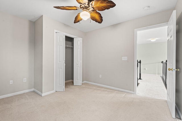 unfurnished bedroom featuring light carpet, ceiling fan, and a closet