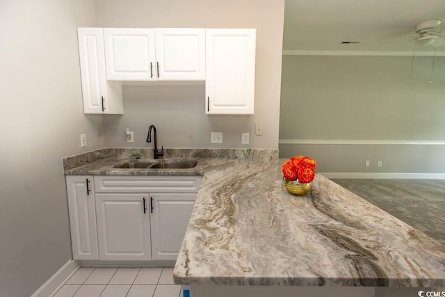 kitchen with ornamental molding, sink, light tile patterned flooring, white cabinets, and ceiling fan