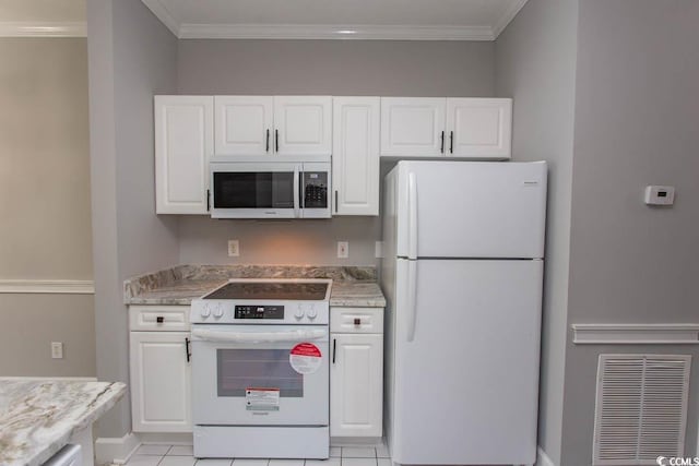 kitchen with light tile patterned floors, white cabinetry, light stone countertops, ornamental molding, and white appliances