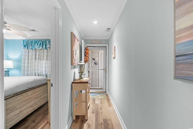 hall with wood-type flooring and ornamental molding