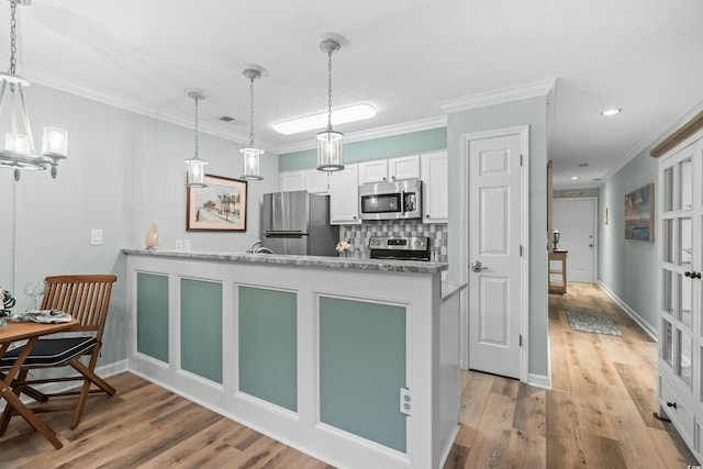 kitchen featuring white cabinetry, kitchen peninsula, stainless steel appliances, light wood-type flooring, and crown molding