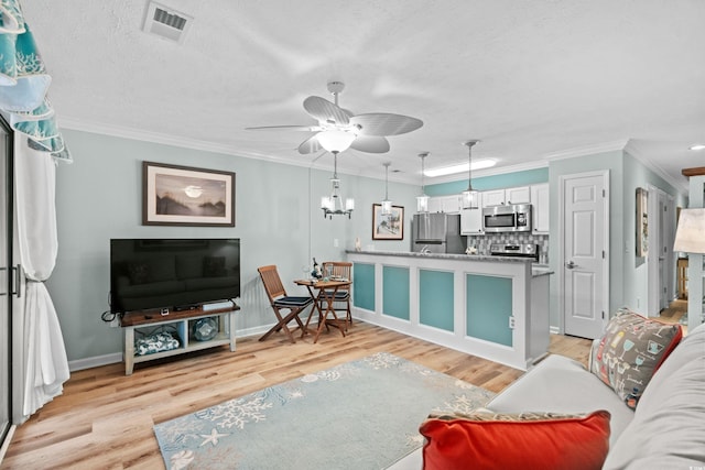 living room with ornamental molding, a textured ceiling, ceiling fan with notable chandelier, and light hardwood / wood-style floors