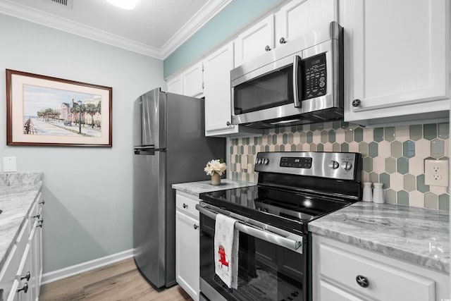 kitchen with light wood-type flooring, light stone counters, white cabinetry, decorative backsplash, and appliances with stainless steel finishes