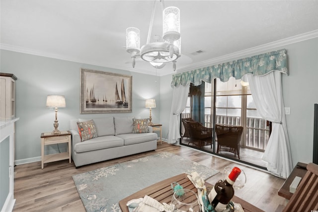 living room featuring ornamental molding, a chandelier, and light hardwood / wood-style floors