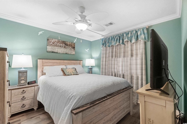 bedroom featuring ornamental molding, wood-type flooring, and ceiling fan