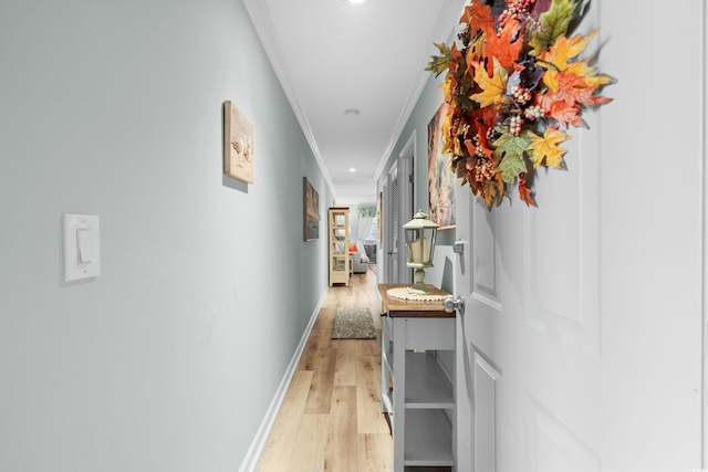 hall with light hardwood / wood-style flooring and ornamental molding