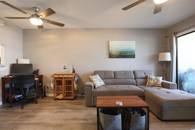 living room featuring ceiling fan and light hardwood / wood-style floors