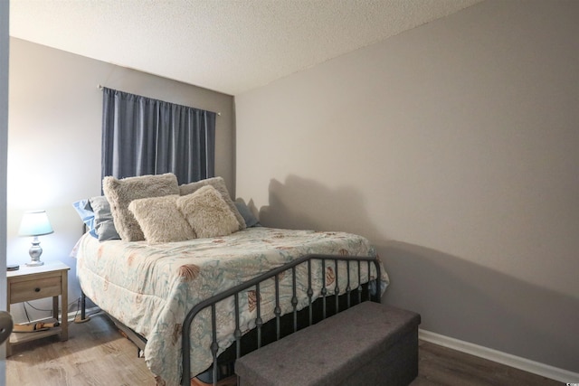 bedroom featuring a textured ceiling and hardwood / wood-style floors