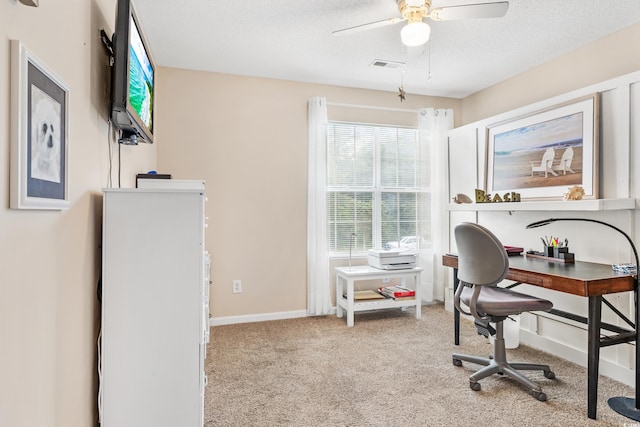 office area with light carpet, ceiling fan, and a textured ceiling