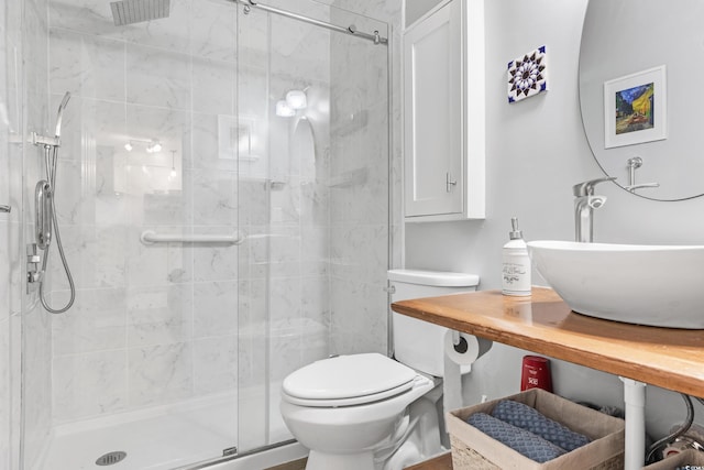 bathroom featuring toilet, sink, and an enclosed shower