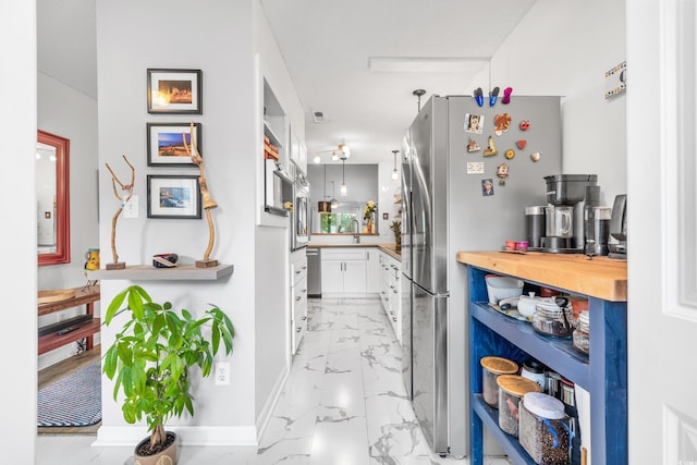 kitchen featuring appliances with stainless steel finishes, white cabinetry, and sink