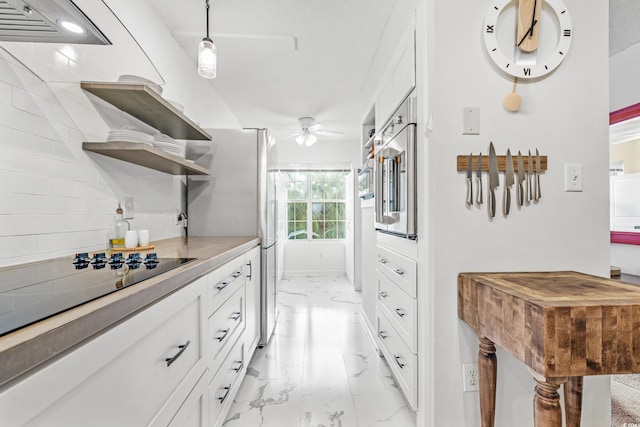 kitchen with white cabinets, ceiling fan, decorative light fixtures, and stainless steel appliances