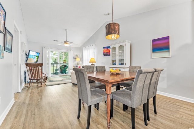 dining space with high vaulted ceiling, ceiling fan, and light hardwood / wood-style flooring