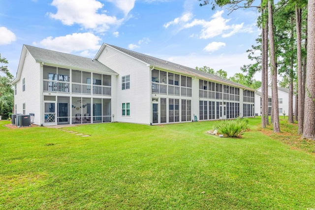 back of property with a sunroom, central AC, and a yard