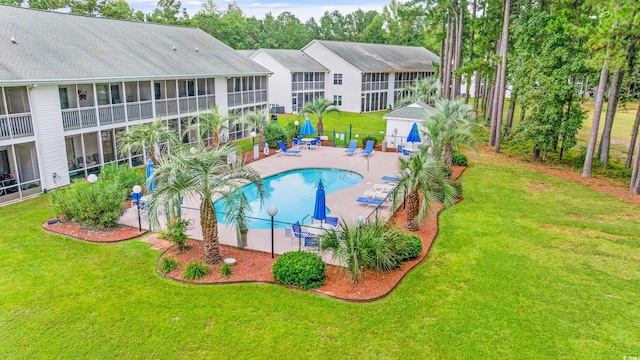 view of pool with a patio and a yard