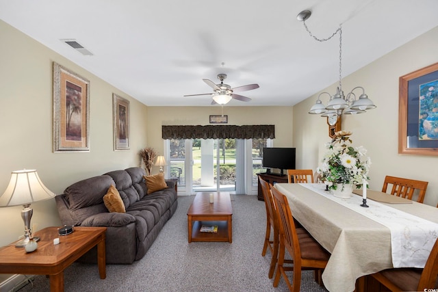 carpeted dining room featuring ceiling fan with notable chandelier