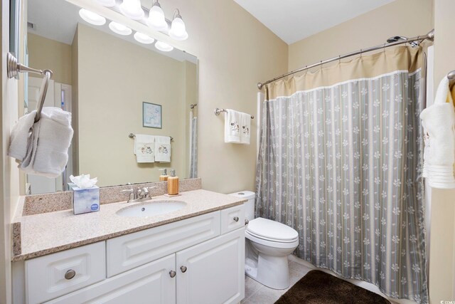 bathroom featuring tile patterned flooring, a shower with curtain, vanity, and toilet