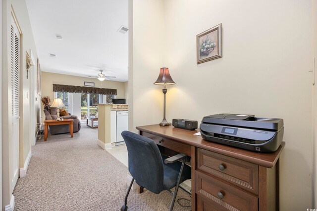 office space featuring light carpet and ceiling fan