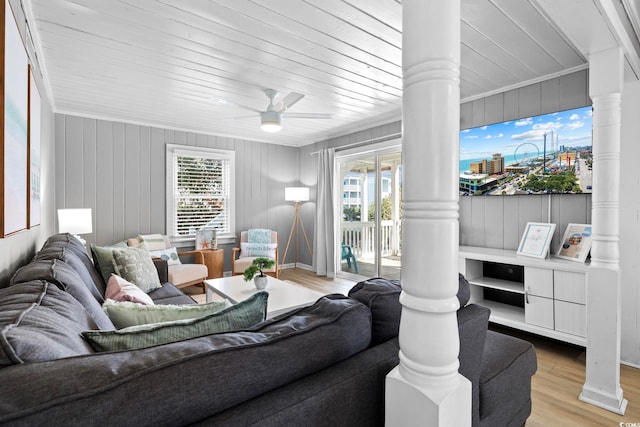 living room featuring light hardwood / wood-style flooring, a wealth of natural light, ceiling fan, and ornate columns