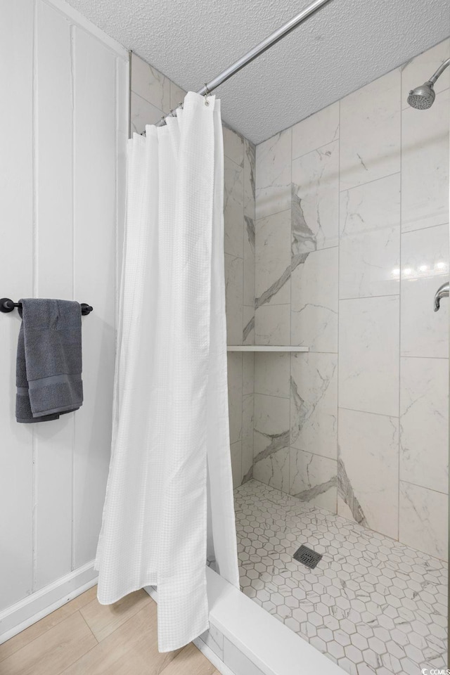 bathroom featuring a shower with curtain, a textured ceiling, and hardwood / wood-style floors