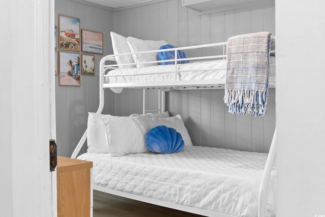 bedroom featuring wood walls and hardwood / wood-style floors