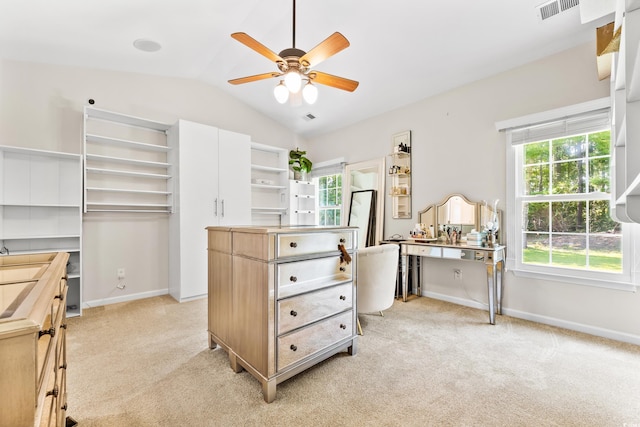 walk in closet with vaulted ceiling, light carpet, and ceiling fan