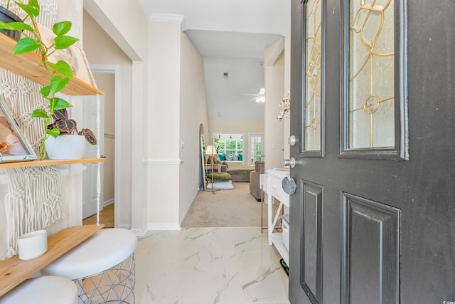 entrance foyer featuring ceiling fan and ornamental molding