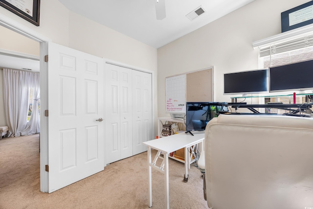 carpeted office space with ceiling fan