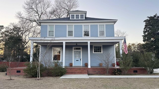 view of front of property with a balcony and a front lawn