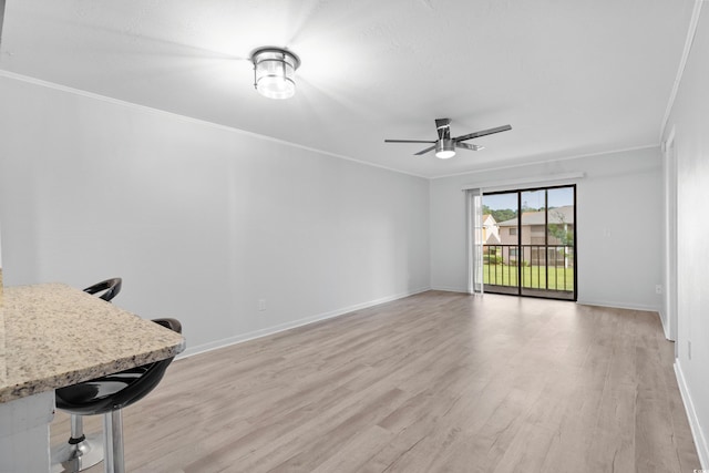 unfurnished living room with light wood-type flooring, ceiling fan, and crown molding