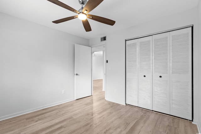 unfurnished bedroom with ceiling fan, light hardwood / wood-style flooring, and a closet