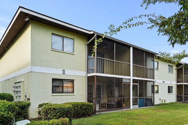 back of property featuring a sunroom and a yard