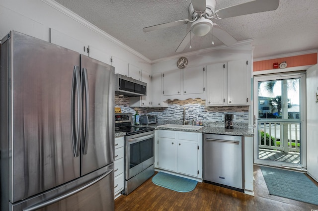 kitchen featuring white cabinets, dark hardwood / wood-style flooring, stainless steel appliances, ceiling fan, and sink